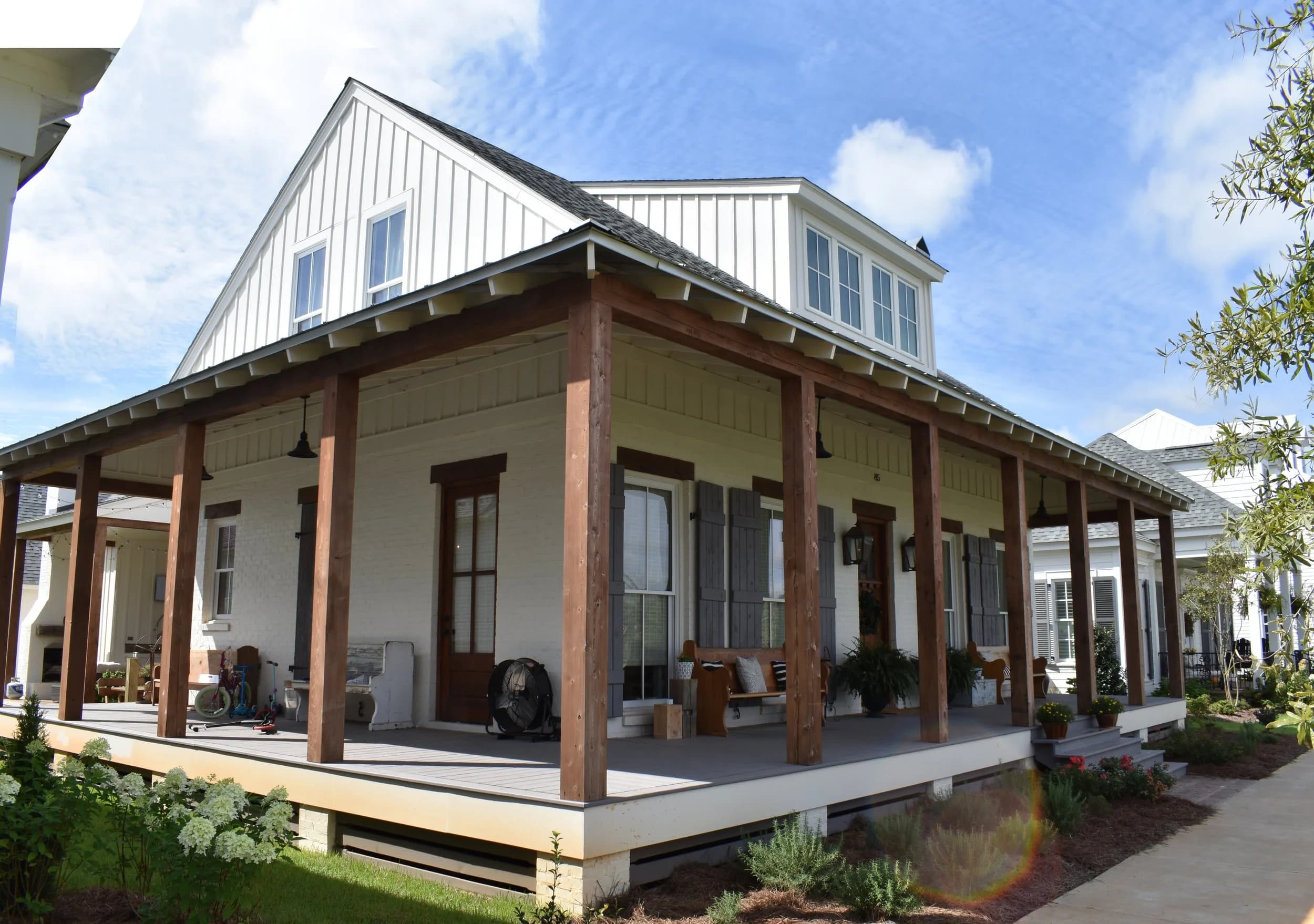 Two-story white house with porch and garden